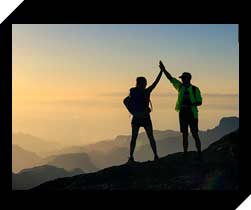 Hikers high five on a mountain summit