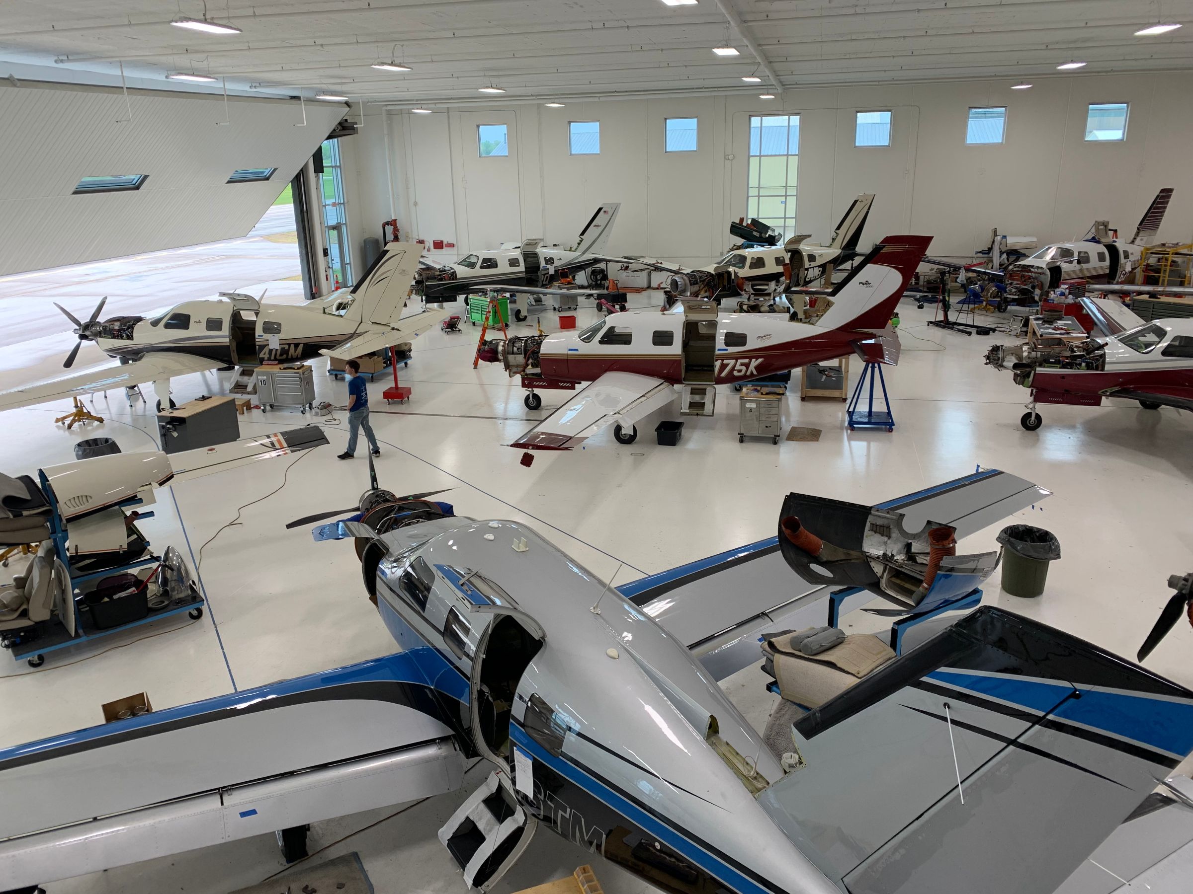 Aircraft maintenance garage with seven airplanes visible.